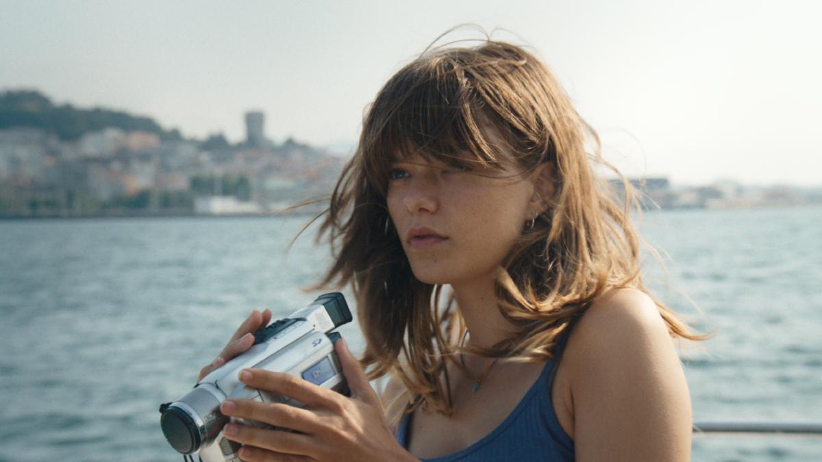 ROMERÍA, 2025, girl in bathing suit holding camcorder near body of water 