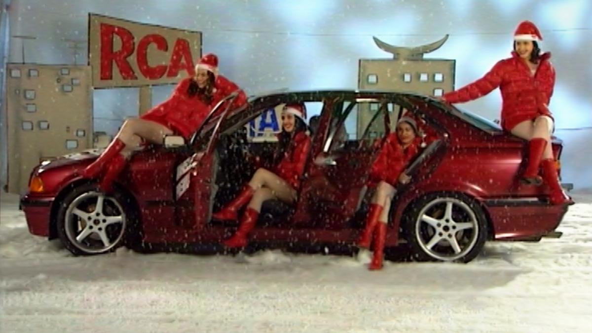 EIGHT POSTCARDS FROM UTOPIA, 2024, four women in Santa outfits and red boots sitting on top of and inside of red car with doors open