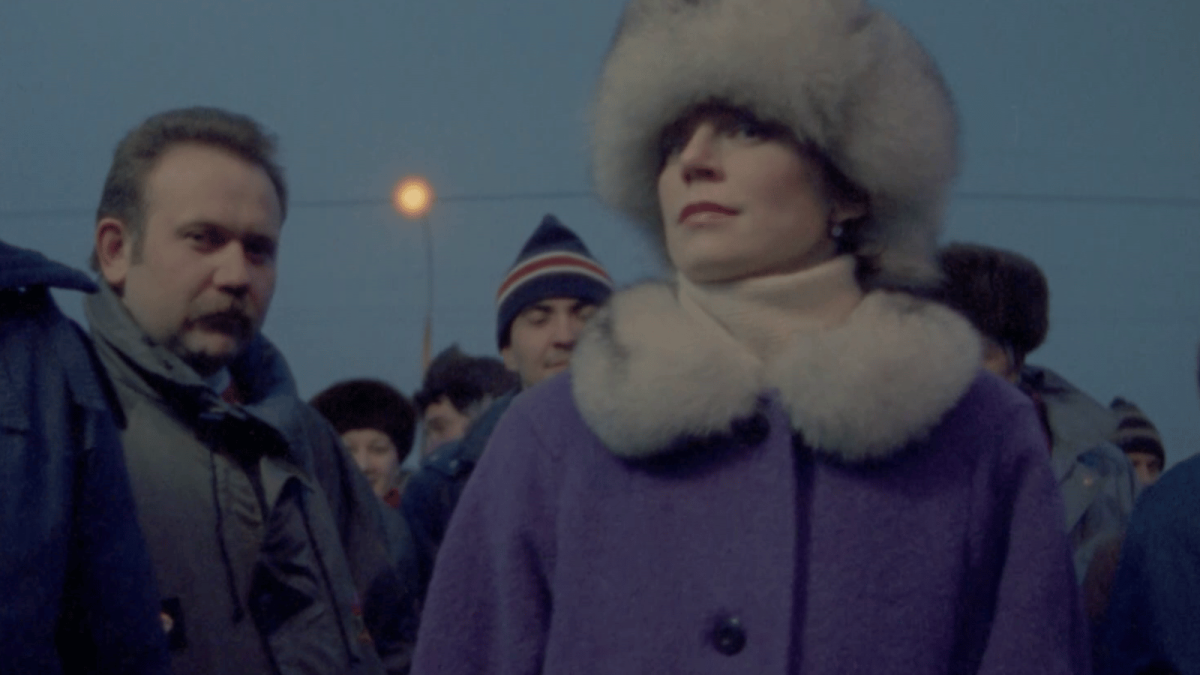 FROM THE EAST, 1993, people in winter clothing standing outside with moon above