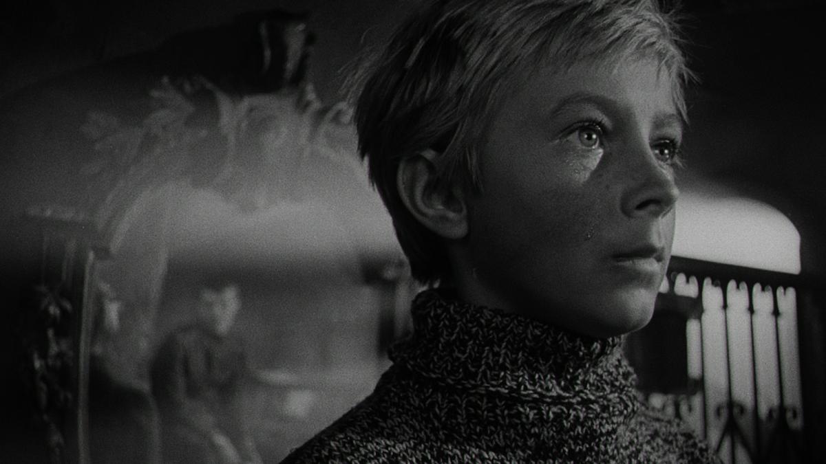 IVAN'S CHILDHOOD, 1962, black and white still of young boy wearing sweater and looking sideways into the distance