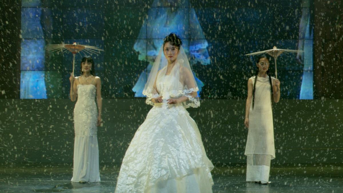 THE WORLD, 2004, three women in white dresses performing on stage holding umbrellas