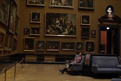 woman sitting on bench in art museum