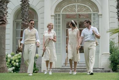 two couples walking on lawn in formal tennis outfits