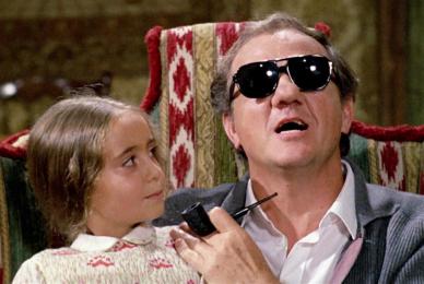 man with sunglasses on sitting in chair with young girl