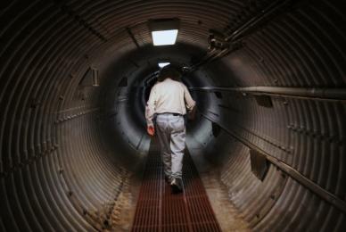 man walking through underground tunnel