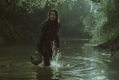 woman walking through shallow lake water