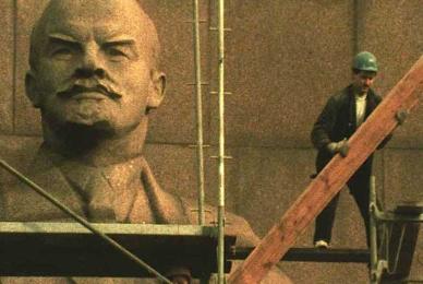 man on platform with Stalin statue behind him