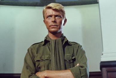 blonde man in military uniform standing with arms crossed