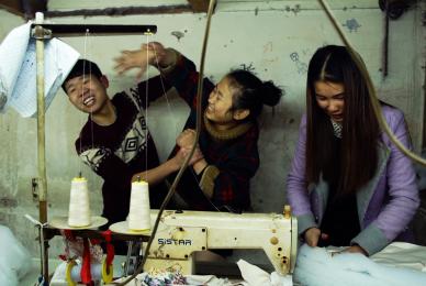 young people laughing and playing in front of sewing machine