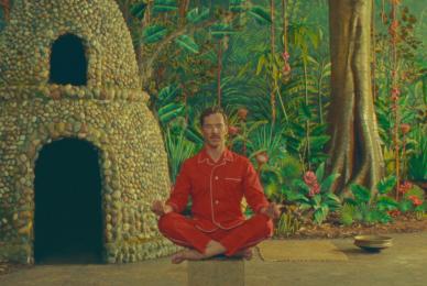 man wearing red sitting and meditating in forest