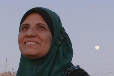 woman in hijab standing looking in distance with moon behind her