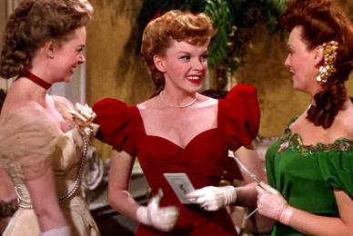 three woman in formal dresses smiling
